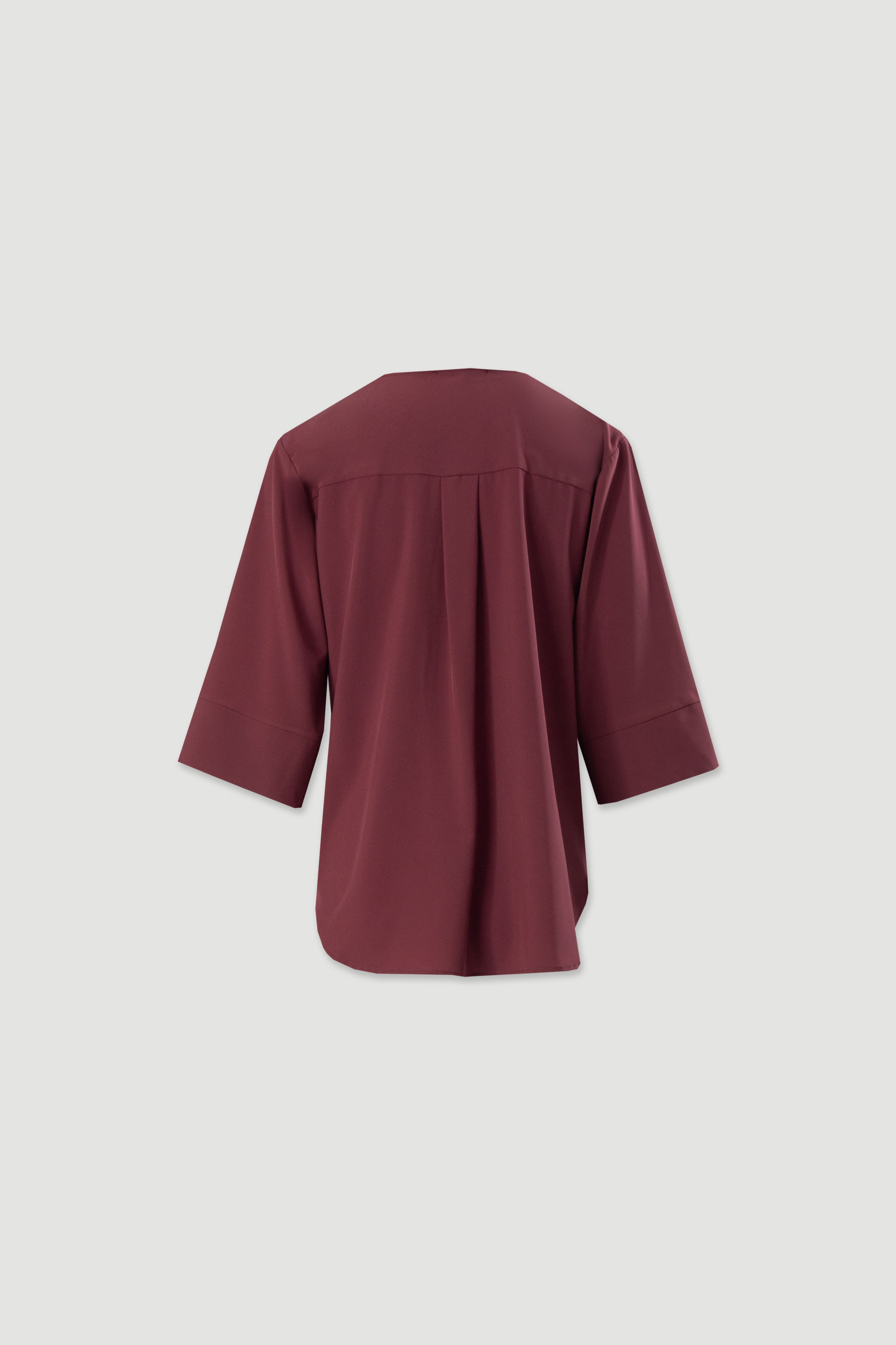 Asymmetric tunic with metallic detail on the neckline