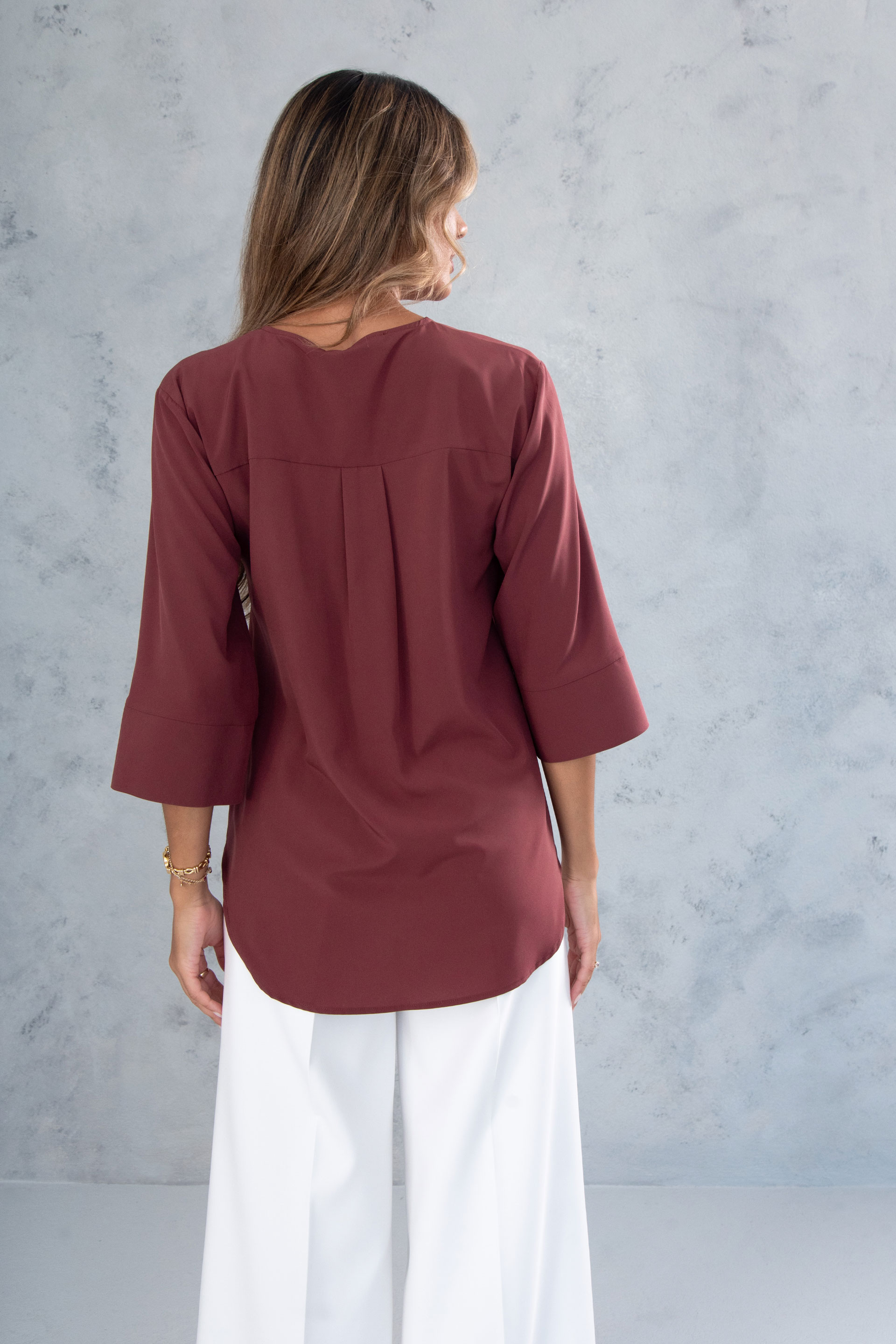 Asymmetric tunic with metallic detail on the neckline