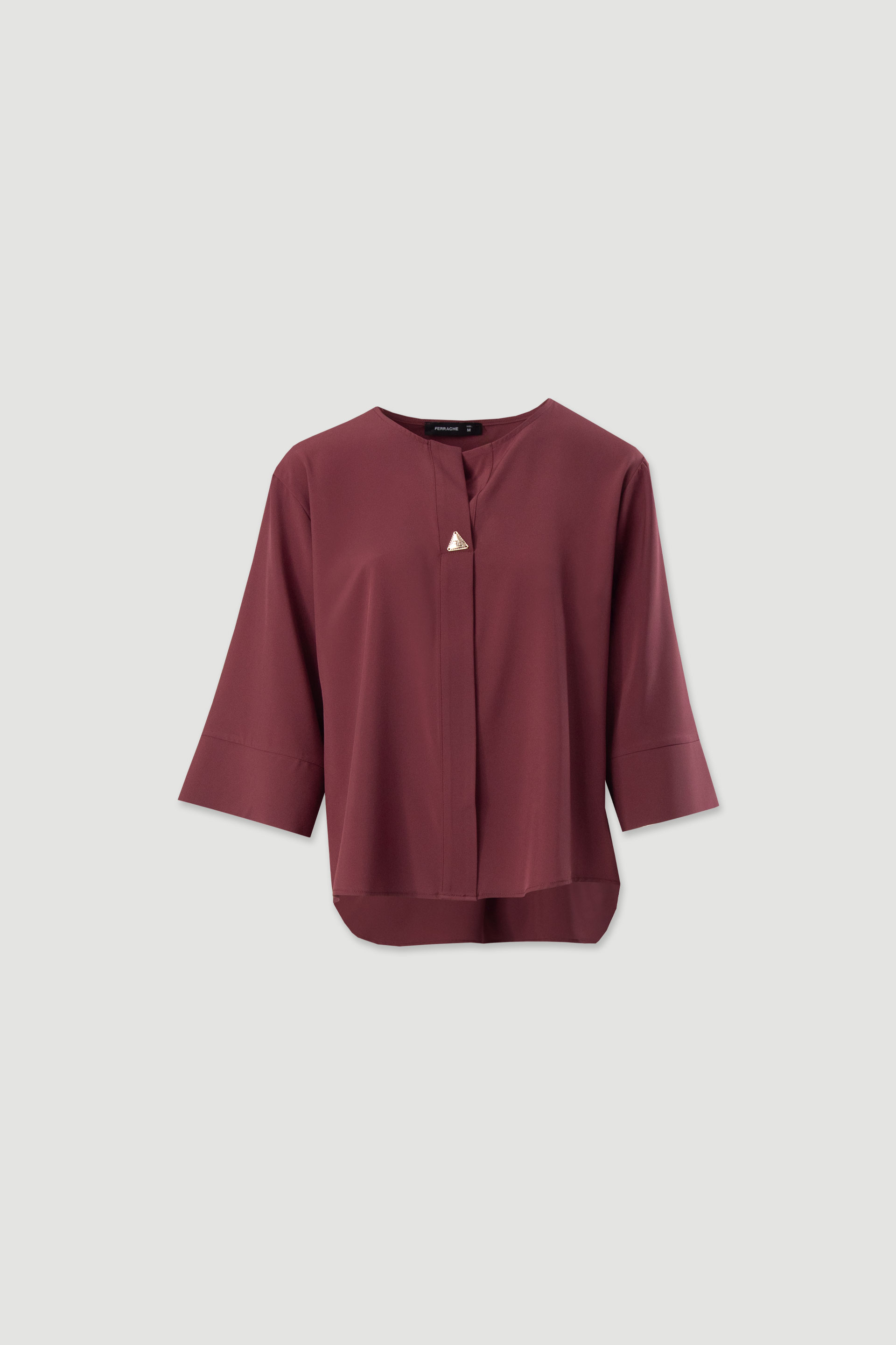 Asymmetric tunic with metallic detail on the neckline