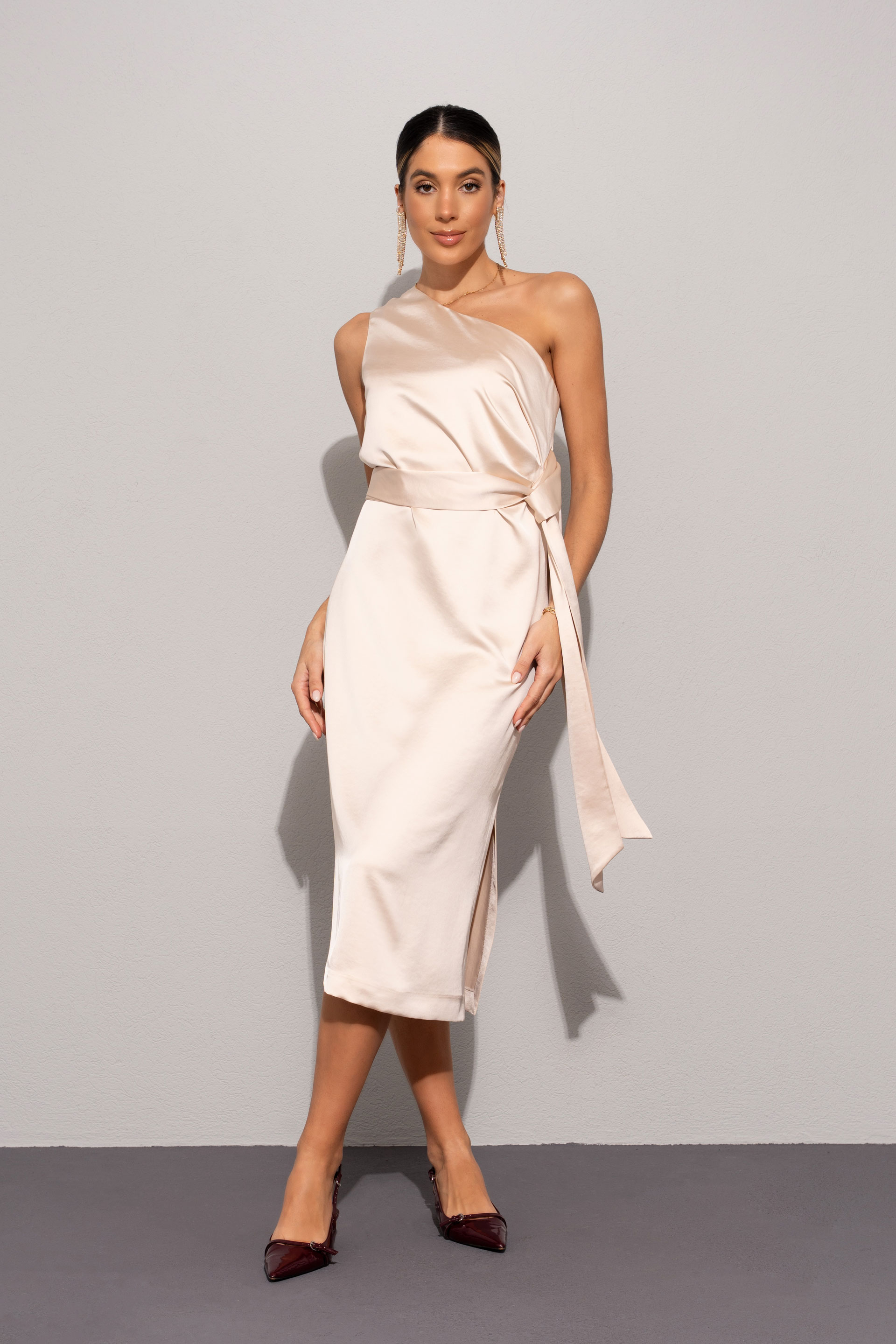 Vestido acetinado com decote assimétrico e laçada na cintura