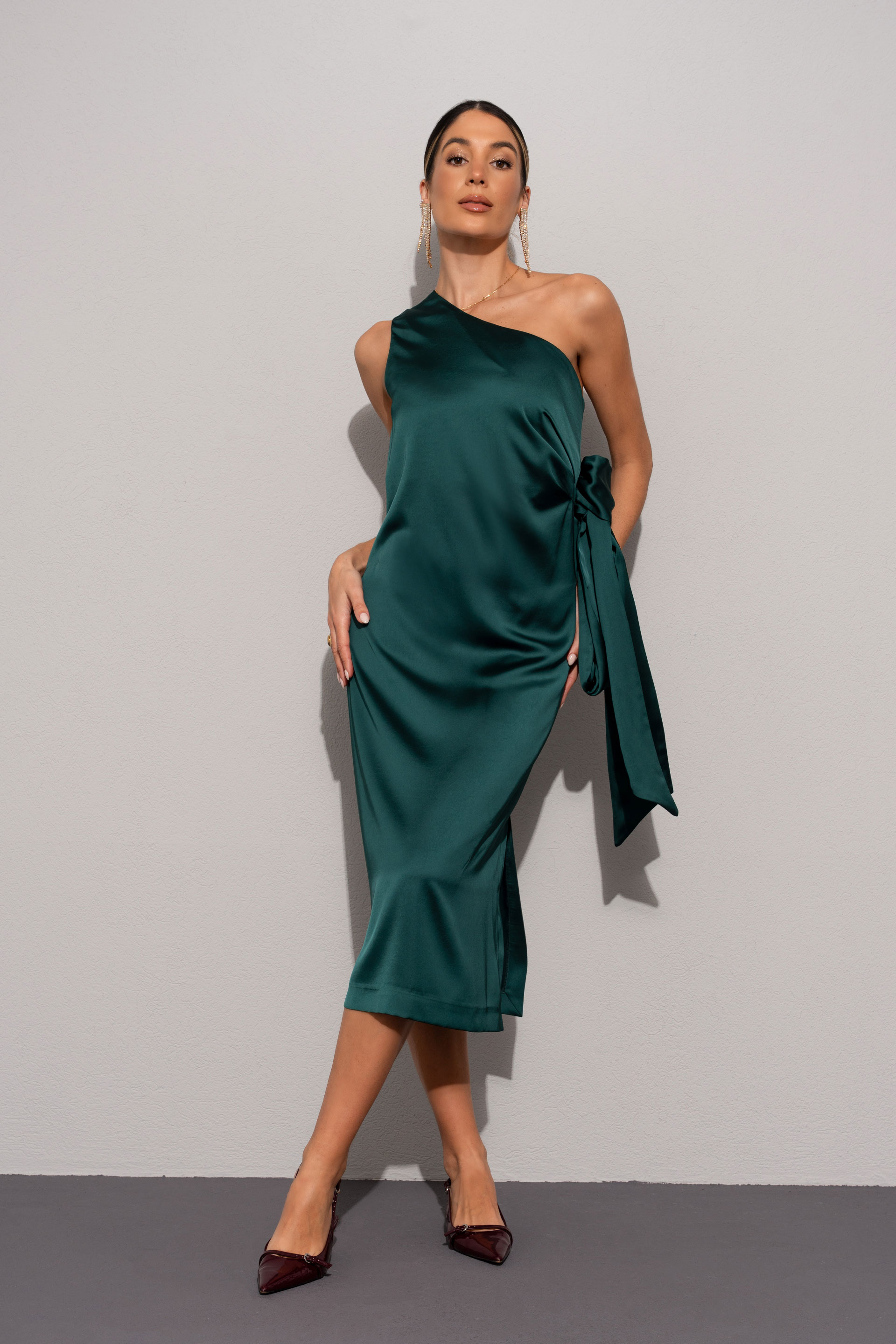 Vestido acetinado com decote assimétrico e laçada na cintura